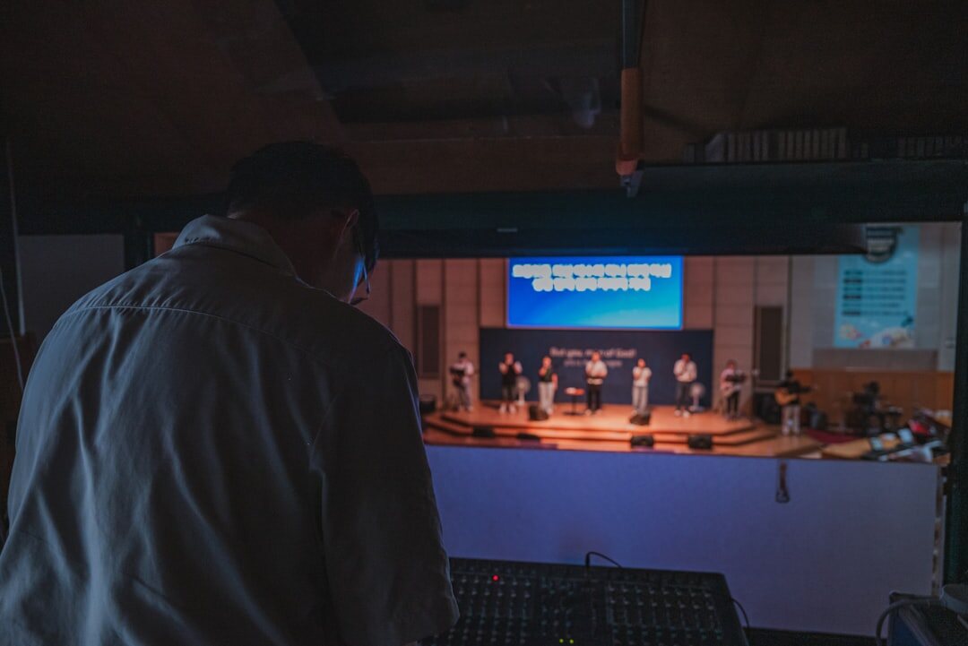 Stage crew adjusting theatrical lighting rig above a stage